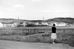 Das noch unbebaute Gewandt Pfaffenäcker 1964. Blick etwa vom heutigen Gemeindezentrum auf die Kaiserslauterer Straße; die Pfeile zeigen auf die Maikammer- und die Edenkobener Straße